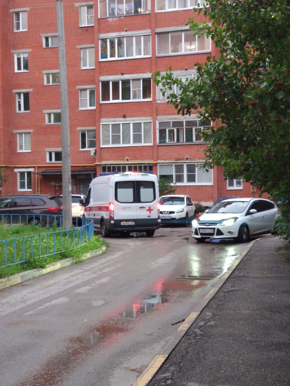 Фото: карета скорой помощи во дворе жилого дома; автомобильные номера скрыты